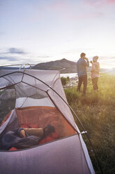 Paar steht in der Nähe des Zeltes, trinkt heiße Getränke und betrachtet die Aussicht, Heeney, Colorado, Vereinigte Staaten - ISF04418