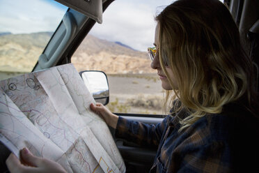 Woman reading map in car, Death Valley National Park, California, US - ISF04434