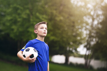 Junge hält Fußball und schaut weg - ISF04468