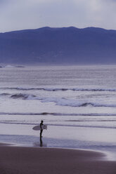 Junger männlicher Surfer mit Blick über das Meer, Morro Bay, Kalifornien, USA - ISF04494