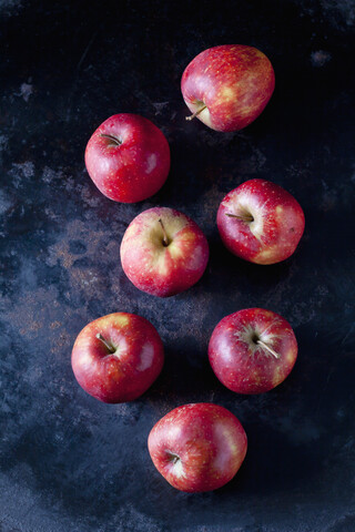 Sieben rote Äpfel auf dunklem Grund, lizenzfreies Stockfoto