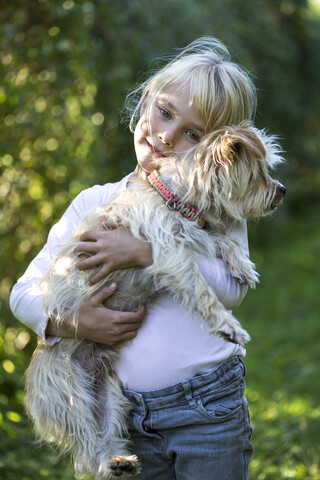 Portrait of happy little girl with her dog in the garden stock photo