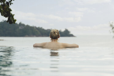 Thailand, Phuket, Rückenansicht einer Frau beim Entspannen im Infinity-Pool - CHPF00466