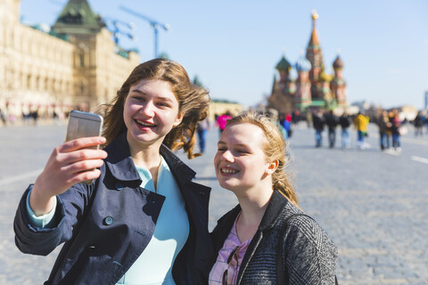 Russland, Moskau, Zwei Teenager-Mädchen machen ein Selfie auf dem Roten Platz in der Stadt, lizenzfreies Stockfoto