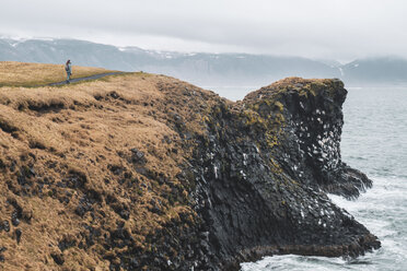 Island, junger Wanderer mit Blick auf die Küste - KKAF01013