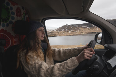 Iceland, young woman driving van - KKAF01020