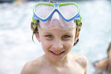 Porträt eines Jungen mit Schwimmbrille auf dem Kopf im Freibad - ISF04522