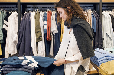 Shopper making decision in clothes shop - ISF04566