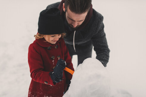 Vater und Tochter bauen Schneemann - ISF04598