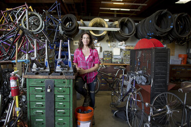 Porträt einer reifen Frau in einer Fahrradwerkstatt - ISF04604