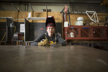Portrait of female metalsmith at workshop bench - ISF04612