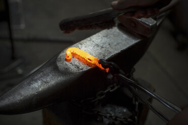 Rotglühender Metallstab auf dem Amboss einer Metallwerkstatt - ISF04619