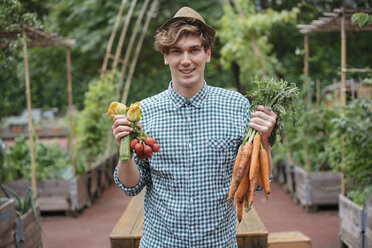 Mann im Garten hält lächelnd Karottensträuße - ISF04676