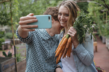 Pärchen im Garten mit Karotten, Selfie machen - ISF04678