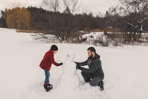 Vater und Tochter bauen Schneemann - ISF04740