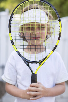 Porträt eines Jungen, der einen Tennisschläger vor das Gesicht hält - ISF04754