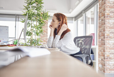 Woman sitting at desk looking away - ISF04787