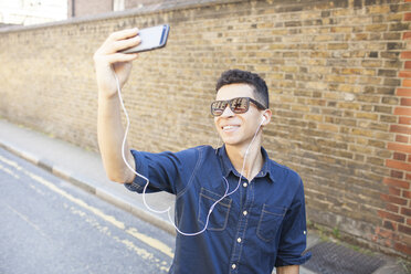 Junger Mann im Freien, Selfie machen, Smartphone benutzen - ISF04884