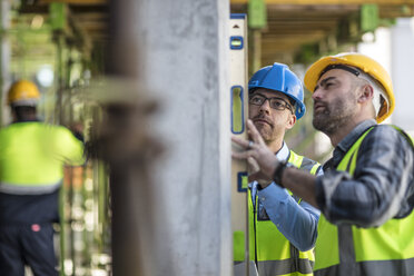 Project manager and construction worker using spirit level - ISF04965