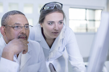 Two laboratory workers looking at computer screen - ISF04982