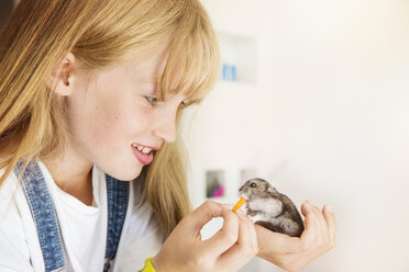 Girl feeding hamster - ISF04997