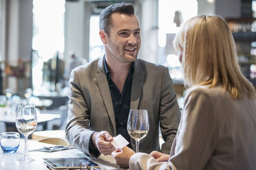 Geschäftsmann und Geschäftsfrau machen sich beim Mittagessen im Restaurant bekannt - ISF05009