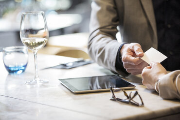 Businessman and businesswoman making introductions at lunch in restaurant - ISF05010