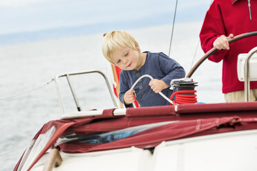 Young boy on sailing boat with great grandfather, mid section, Geneva, Switzerland, Europe - ISF05026