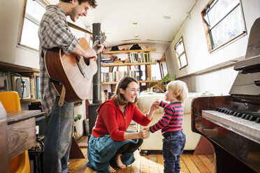 Family with baby boy living on barge playing guitar and dancing - ISF05039