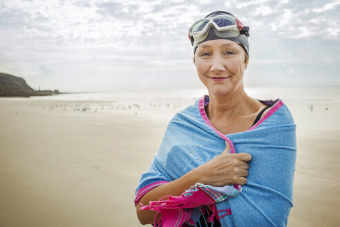 Woman on beach with wrap over shoulders, Folkestone, UK - ISF05040