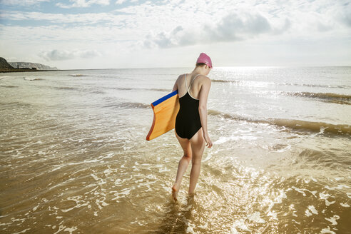 Junge Frau mit Surfbrett im Meer, Folkestone, UK - ISF05053