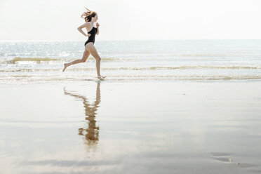 Junge Frau läuft am Strand, Folkestone, UK - ISF05062