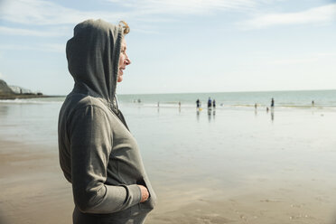 Frau am Strand mit Kapuzenoberteil, Folkestone, UK - ISF05064