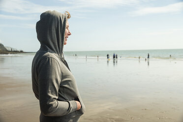 Woman on beach in hooded top, Folkestone, UK - ISF05064