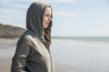 Junge Frau am Strand mit Kapuzenoberteil, Folkestone, UK - ISF05066