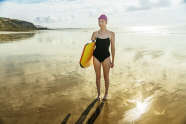Junge Frau mit Surfbrett am Strand, Folkestone, UK - ISF05114