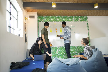 Junge Geschäftsleute mit Laptop und Whiteboard in einem kreativen Konferenzraum - ISF05170