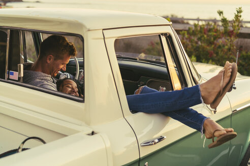 Romantisches Paar in einem Pickup-Truck mit aus dem Fenster gehobenen Beinen in Newport Beach, Kalifornien, USA - ISF05207