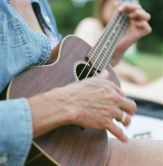 Ältere Frau, im Freien, Ukulele spielend, Mittelteil, Nahaufnahme - ISF05231