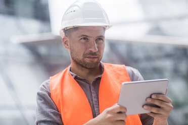 Man wearing hard hat and high viz using digital tablet - ISF05241