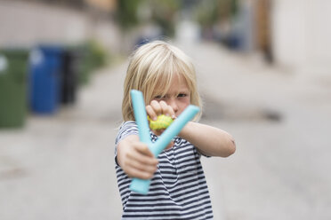 Boy aiming catapult at camera - ISF05303