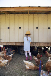 Young girl on farm, collecting eggs from chicken coop - ISF05454