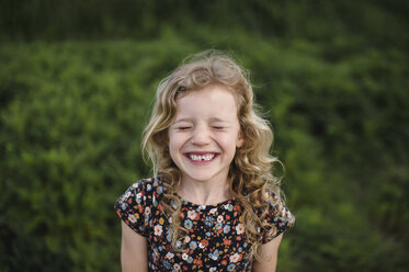 Portrait of girl with wavy blond hair and missing tooth in field - ISF05469