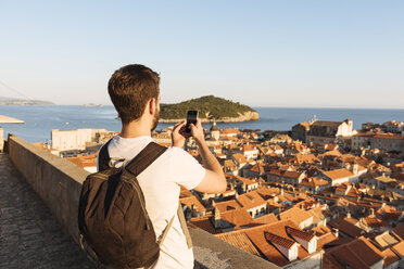 Mann fotografiert das Meer über den Dächern, Dubrovnik, Dubrovacko-Neretvanska, Kroatien, Europa - ISF05515