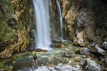 Hiker looking at waterfall, Accursed mountains, Theth, Shkoder, Albania, Europe - ISF05522