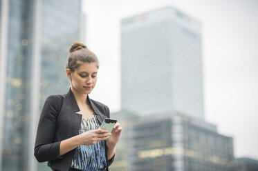 Geschäftsfrau mit Mobiltelefon, Canary Wharf, London, UK - ISF05599