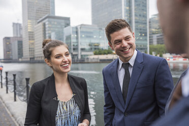 Businessman and businesswoman in discussion outdoors, Canary Wharf, London, UK - ISF05600