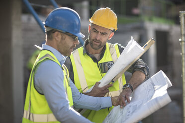 Projektleiter und Bauarbeiter sehen sich Pläne an - ISF05609