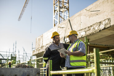 Construction workers in discussion on building site - ISF05624