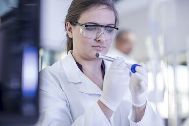 Laboratory worker writing details on test tube - ISF05656